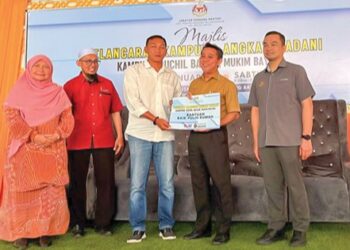 JASRI Kasim (dua dari kanan) menyerahkan replika sebagai simbolik bantuan baik pulih rumah kepada wakil penduduk di  Kampung Guchil  Bayam, Kota Bharu, Kelantan. – mingguan/ ROSLIZA MOHAMED