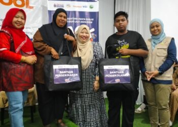 REHA Ghazali (dua dari kiri) bersama anaknya (dua dari kanan) menerima bantuan Kembali ke Sekolah daripada Ainol Shaharina Sahar (tengah) di Bukit Gading Tanah Merah, Kelantan. – UTUSAN/ROHANA ISMAIL