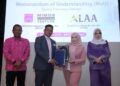 MOHAMAD Azriani Abd. Aziz (dua kiri) dan Husna Nashim ketika pertukaran dokumen MoU.