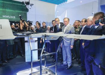 Anwar Ibrahim (lima dari kanan) bersama Mohamed Khaled Nordin (tiga dari kanan) melawat reruai pameran Industri Pertahanan selepas Majlis Peluncuran Dasar Industri Pertahanan Negara (DIPN) 
di Pusat Pameran dan Dagangan Antarabangsa Malaysia (MITEC) semalam. – UTUSAN/FARIZ RUSADIO