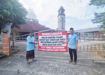 AZRI Yusof (kiri) notis penutupan Masjid Kampung Penarik yang uzur dan runtuh Setiu, Terengganu. – MINGGUAN/WAN ZURATIKAH IFFAH WAN ZULKIFLI