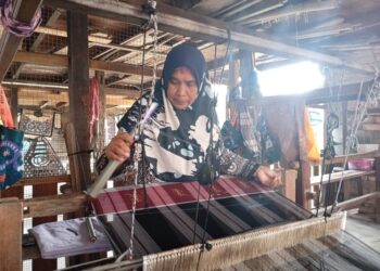 GAYAH Awang sedang menenun songket di rumahnya di Kampung Pasir Panjang, Kuala Terengganu, Terengganu. – UTUSAN/ERMA YUSNIDA JUSOH