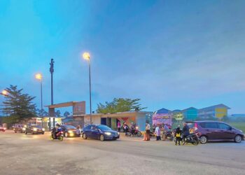 IBU bapa menghantar anak mereka ke sekolah di Teluk Intan. –  UTUSAN/AIN SAFRE BIDIN