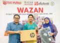 SEORANG pelajar tahun 1 Universiti Putra Malaysia, Muhammad Izwan Haziq (tengah), menerima sumbangan bantuan komputer riba daripada pegawai Wazan UPM Mohd. Rizal (kiri) dan Maznur Nazila di Serdang baru-baru ini.