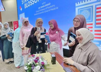 RANIA bergambar bersama orang ramai yang menghadiri majlis pelancaran bukunya di Hospital Canselor Universiti Kebangsaan Malaysia di Kuala Lumpur, baru-baru ini.