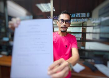 AHMAD Fauzan Mohd. Zain menunjukkan borang permohonan untuk mendapatkan lesen mendulang emas di PTG negeri di Kompleks Kota Darulnaim, Kota Bharu, Kelantan hari ini-UTUSAN/YATIMIN ABDULLAH.