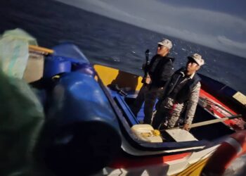 ANGGOTA Maritim Malaysia memeriksa tong plastik berwarna biru berisi petrol yang ditemukan atas sebuah bot pam di perairan Kudat, Sabah.