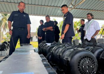 MUHAMMAD Abdul Halim (kiri) meninjau aksesori yang dirampas dipercayai digunakan bagi aktiviti perlombongan bitcoin dalam serbuan di sekitar Kuala Perlis dan Kangar pada minggu lalu. -UTUSAN/ASYRAF MUHAMMAD.