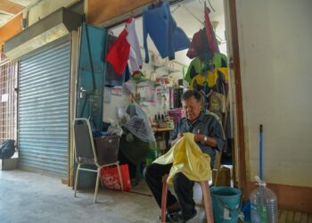 HAMIDON Ahmad dan isterinya, Intan Baharom sedang menyiapkan tempahan pelanggan setia mereka dengan kaedah jahitan tangan di Bazar Melayu, Kangar, Perlis yang beroperasi sejak 1957. – UTUSAN/IZLIZAN OTHMAN