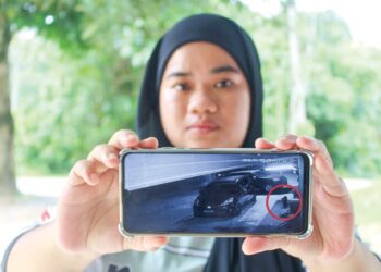 NURUL Atikah Mohd. Raus menunjukkan rakaman CCTV yang memaparkan kelibat harimau kumbang yang berkeliaran di hadapan rumahnya di Kampung Kemin Tanjung, Kuala Klawang, Jelebu. 
– UTUSAN / NOR SHAFIQAH MOHD GHAZALI