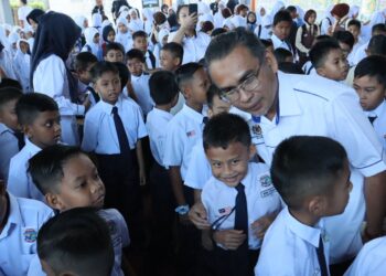 MOHAMAD Dziauddin Mat Saad (kanan) beramah mesra dengan murid Tahun Satu ketika menghadiri sesi pemuafakatan antara KPM dan PDRM di SK Tan Sri Awang Had Salleh, Balik Pulau, Pulau Pinang hari ini.-UTUSAN/DANIAL SAAD