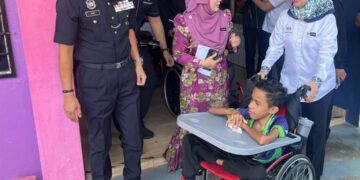 RUSMINI Ku Ahmad (kanan) menyantuni salah seorang pelajar Program Pendidikan Khas Intergrasi (PPKI) semasa melakukan tinjauan di Sekolah Menengah Kebangsaan (SMK) Dato Ali Ahmad bersempena hari pertama persekolahan di Kangar, Perlis hari ini. -UTUSAN/ASYRAF MUHAMMAD