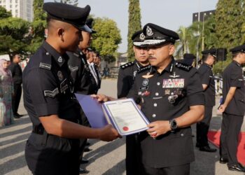MOHD. Yusoff Mamat (kanan) menyampaikan surat penghargaan kepada anggotanya semasa 
Perhimpunan Bulanan Polis Peringat Ibu Pejabat Polis Kontinjen Kelantan (IPK) Kota Bharu, Kelantan hari ini-UTUSAN/KAMARUL BISMI KAMARUZAMAN.