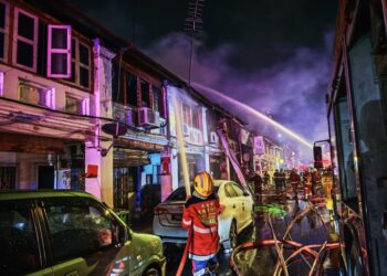 ANGGOTA bomba bertungkus-lumus memadamkan kebakaran melibatkan lima unit rumah kedai dua tingkat di Lebuh Presgrave, George Town, Pulau Pinang malam tadi.-GAMBAR/JBPM PULAU PINANG