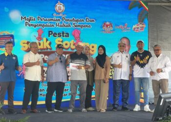 ABU Bakar Hamzah (tiga dari kiri) menyampaikan hadiah utama bernilai RM10,000 kepada pemenang semasa Majlis Penutup Pesta Sauk Sotong Perlis 2026 di Tapak MBI Kuala Perlis, Perlis, hari ini. -UTUSAN/ASYRAF MUHAMMAD