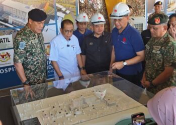 MOHAMED Khaled melihat plan Pembangunan Hospital ATM baharu bernilai RM320 juta yang dijangka siap pada Januari 2029 dengan kapasiti 150 katil sempena lawatan kerja ke Kem Terendak, Melaka, hari ini. - UTUSAN/AMRAN ALI