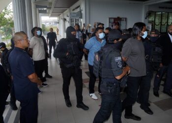 TIGA tertuduh yang ditahan di Mumbai, India Ahad lalu dikawal anggota polis untuk didakwa atas pertuduhan menjadi ahli kumpulan jenayah terancang di Mahkamah Sesyen, Sepang, Selangor. - UTUSAN/FAISOL MUSTAFA