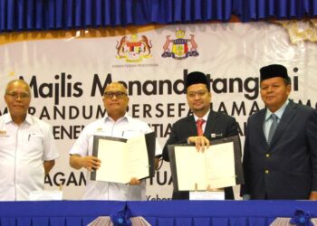 AMINUDDIN Hassim (dua dari kiri) menunjukkan dokumen MoU yang ditandatangani bersama Shaifulfazlee Mohamad (dua dari kanan) di Sekolah Menengah Imtiaz Ulul Albab, Masjid Tanah, Melaka, hari ini. - UTUSAN/AMRAN MULUP