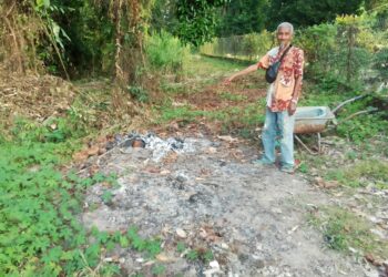 CHE Hisam Che Soh menunjukkan lokasi mangsa diragut semasa sedang membakar sampah Kampung Paloh Rambai, Ketereh dekat Kota Bharu, Kelantan hari ini.