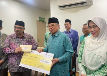 ABANG Johari Abang Openg (tengah) menyampaikan cek bernilai RM20,000 kepada Perkim Kelantan yang diterima oleh Mohamed Fadzli Hassan di Dewan Utama Kompleks Islam Jubli Perak Sultan Ismail Petra, Panji,Kelantan hari ini. UTUSAN/ROSMIZAN