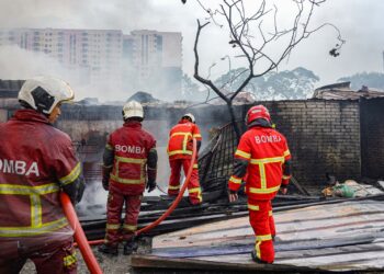 ANGGOTA bomba memadam dan mengawal kebakaran melibatkan deretan premis kedai di Taman Medan, Petaling Jaya, hari ini.-UTUSAN/ISKANDAR ISHAK