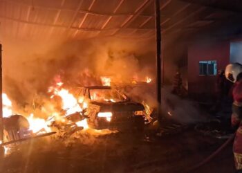 PASUKAN bomba memadamkan kebakaran garaj tidak kekal yang turut memusnahkan enam kenderaan dan dua motosikal di Kampung Lok Batik, Tuaran, Sabah, awal pagi tadi. - UTUSAN/HARDY JOE