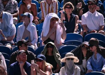 Cuaca panas mendorong penonton  menutup kepala dengan kain semasa menonton perlawanan tenis Terbuka Australia di Melbourne. - AFP