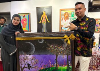 EMMA Maembong (kiri) menyerahkan lukisan kepada Pengarah Perbadanan Muzium Kelantan, Norhalis Mohamed Noor paca program Sepetang Sepetang Bersama Legasi Ismail Embong di Balai Seni Lukis Kota Bharu, Kelantan. - UTUSAN/ROSLIZA MOHAMED