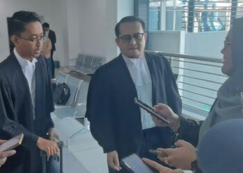 AHMAD Hanir Hambali (dua dari kiri) bersama Mohammad Solehheen Mohammad Zaki (kiri) ketika ditemui selepas prosiding kes GISB di Kompleks Mahkamah Kangar, Perlis, hari ini. - UTUSAN/ASYRAF MUHAMMAD