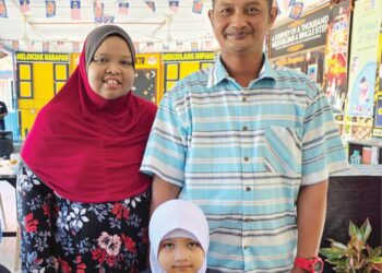 RAISSYAH Aafiyah Rahmat bersama bapanya, Rahmat Baok dan ibunya, Suzana Aziz ketika memulakan sesi persekolahan 2026 di SK Tebing Rebak di Bagan Datuk semalam. - UTUSAN/AIN SAFRE BIDIN
