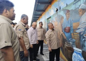 SAARANI Mohamad melihat mural yang dihasilkan pada dinding di Laman Memori Beruas Dataran Gangga Negara di Beruas.
