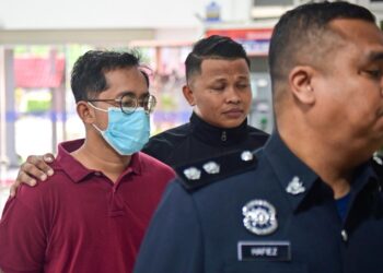 AHMAD Faisal Mohd. Sharani (kiri) dibawa keluar dari Mahkamah Kuala Terengganu selepas mengaku bersalah atas dua pertuduhan menggunakan wang palsu dan cubaan mencuri seutas gelang tangan emas. - UTUSAN/PUQTRA HAIRRY