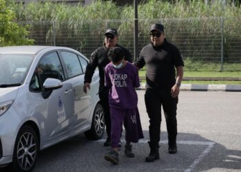 MOHD. Nazrulhisam Mohd. Nordin dibawa anggota polis semasa menghadiri prosiding perbicaraan di MahkAmah Kota Bharu, Kelantan. - UTUSAN/KAMARUL BISMI KAMARUZAMAN