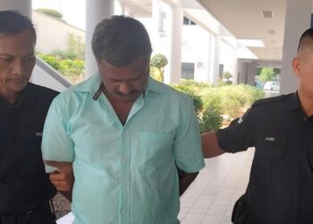 TERTUDUH diiringi anggota polis dibawa keluar dari Mahkamah Majistret Ayer Keroh selepas berdepan pertuduhan mencabul kehormatan seorang pemandu e-hailing warga emas, hari ini. - UTUSAN/AMRAN ALI