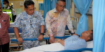 ADLY Zahari melawat Mohamad Zulfika Mohiddi diiringi Shamsuddin Ludin (kiri) yang mendapatkan rawatan di Unit Kecemasan, Hospital Melaka hari ini. - UTUSAN/AMRAN MULUP