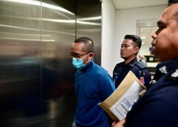 AHMAD Faisal Mohd. Sharani (depan) semasa dibawa ke Mahkamah Sesyen Kuala Terengganu. - UTUSAN/PUQTRA HAIIRY