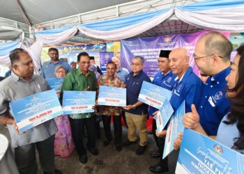 AARON Ago Dagang (tengah) menyampaikan cek cura kepada 10 KRT melalui Program Satelit Komuniti Rakyat Madani Tahun 2026 (Kluster Jabatan Perpaduan Negara dan Integrasi Nasional) Peringkat Negeri Perak di Pusat Nadi Kampung Dato' Ahmad Said Tambahan 2, di Ipoh hari ini.