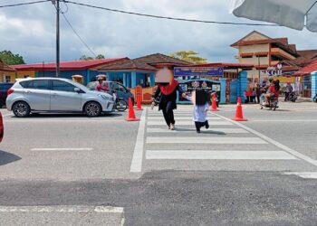 IBU BAPA menggesa supaya lampu isyarat dipasang untuk keselamatan murid-murid Sekolah Kebangsaan ( SK) Gong Badak, Kuala Nerus, Terengganu. – UTUSAN/ERMA YUSNIDA JUSOH