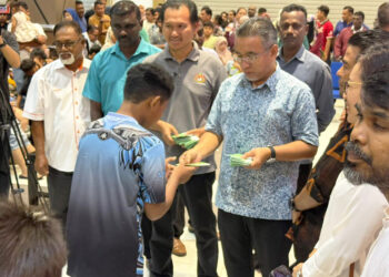 ADLY Zahari menyampaikan baucar kepada penerima sempena Program Jom Shopping Barangan Sekolah 2026 di sebuah pasar raya di Pulau Sebang, Alor Gajah, Melaka hari ini.-UTUSAN/AMRAN MULUP