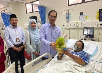 DR. SANIHAH Abdul Halim (tengah) beramah mesra bersama pesakit di Unit Rawatan Strok dan Unit Separa Kritikal (HDU) Neurologi Hospital Pakar Universiti Sains Malaysia (HPUSM) Kubang Kerian, Kelantan. - UTUSAN/ROSMIZAN RESDI