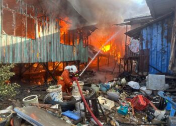 ANGGOTA bomba memadamkan kebakaran di Kampung Dumpil, Putatan, Sabah melibatkan 17 buah rumah, pagi tadi.