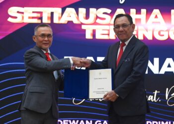 ZULKIFLI Ali (kiri) menyerahkan nota serah tugas kepada  Datuk Mohd. Azmi Mohammad Daham yang bakal menggantikan beliau sebagai Setiausaha Kerajaan Negeri Terengganu.