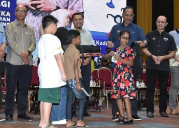 ZAMBRY Abd. Kadir menyampaikan bantuan persekolahan pada Program Kembali ke Sekolah di Manjung hari ini. - UTUSAN/ZULFACHRI ZULKIFLI