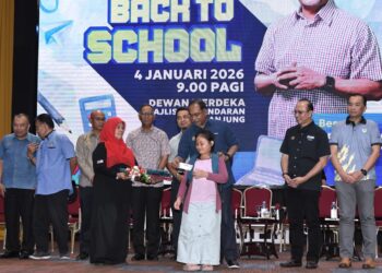 ZAMBRY Abd. Kadir menyampaikan bantuan persekolahan pada Program Kembali ke Sekolah di Manjung hari ini. - UTUSAN/ZULFACHRI ZULKIFLI