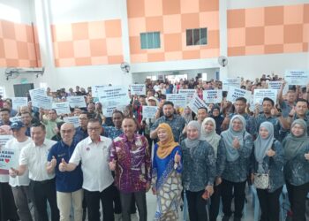 MOHD. Jafni (tengah) bergambar bersama penerima Bantuan Kasih Johor Fasa 3 di Dewan PPR Sri Stulang, Johor Bahru, Johor, semalam.