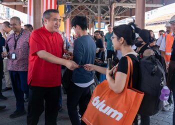 ANTHONY Loke Siew Fook mengedarkan pek cenderahati kepada penumpang KTMB di Stesen Keretapi Seremban hari ini