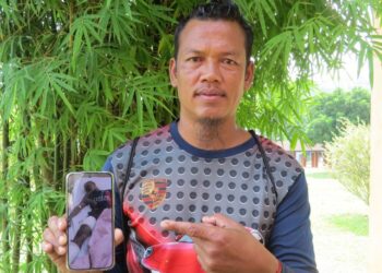 EDDRY Chali menunjukkan gambar Asmir Alang yang dirawat di Hospital Gua Musang, Kelantan selepas cedera diserang seekor beruang matahari semalam.