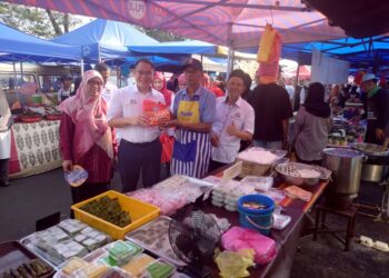 LING Tian Soon (dua kiri) menyampaikan kit kebersihan kepada salah seorang pengusaha ketika melawat Bazar Ramadan Stadium Mini Pontian.