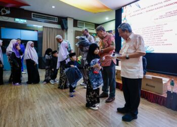 DONALD Lim Siang Chai (kanan) menyampaikan sumbangan kepada anak-anak yatim pada majlis berbuka puasa di Kelab Golf Negara Subang, semalam.-UTUSAN/ SHIDDIEQIIN ZON