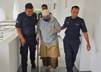 MUHAMMAD Salleh Hamzah diibawa keluar dari Mahkamah Majistret Alor Gajah selepas didakwa atas pertuduhan mencabul seorang wanita yang juga pengikut kuliahnya, tahun lalu. - UTUSAN/AMRAN ALI